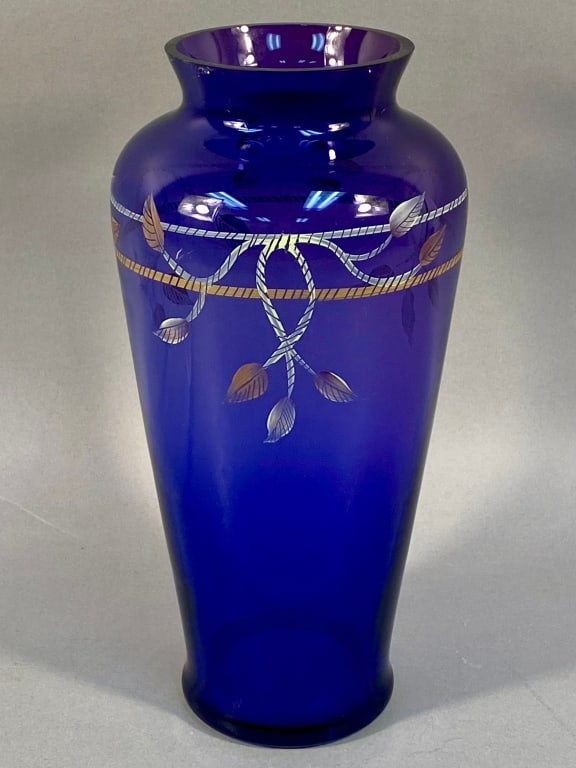 Fenton Hand-Painted Cobalt Blue Glass Vase with Si: A Fenton Hand-Painted Cobalt Blue Glass Vase, featuring a tapered cylindrical body with a slightly flared rim. It is decorated around the upper portion with interwoven silver and gilt rope-twist motif
