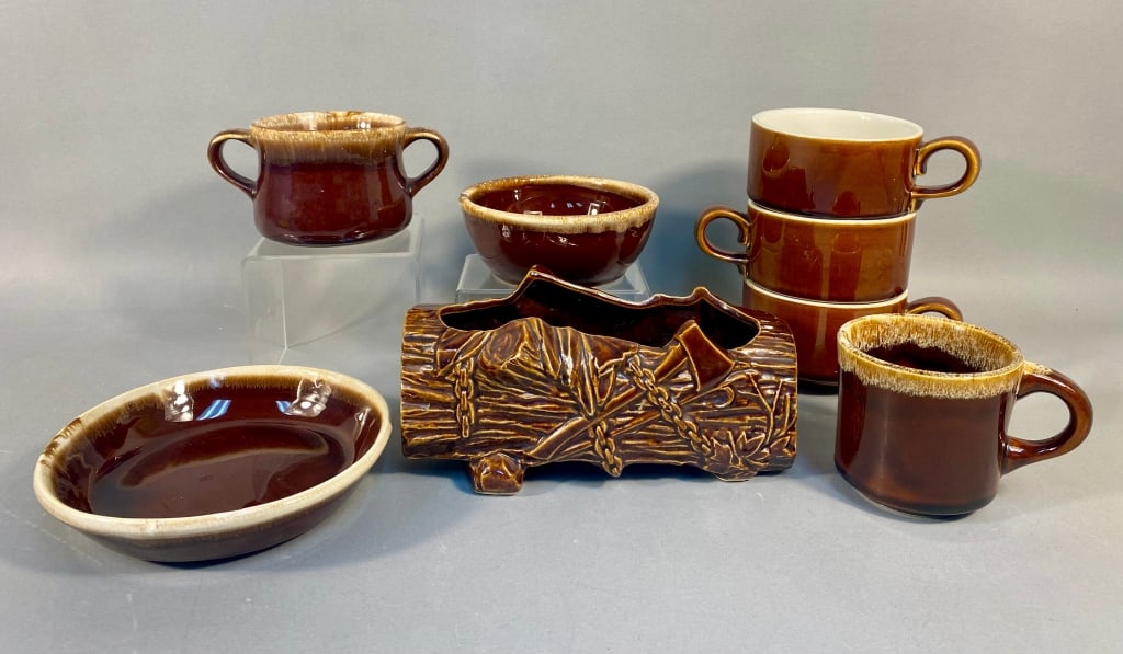 A Collection of American Art Pottery, including a: A collection of American art pottery, primarily featuring glazed ceramic items with a glossy dark brown base and a lighter, creamy tan drip glaze effect at the rims. The group includes a McCoy 'Log an