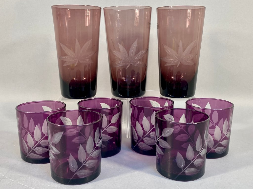 A Set of Nine Purple Etched Glass Tumblers, compri: This lot comprises nine pieces of colored glass drinkware, crafted from a deep purple glass. Each tumbler exhibits a color gradient from a lighter amethyst shade near the rim to a darker, almost black