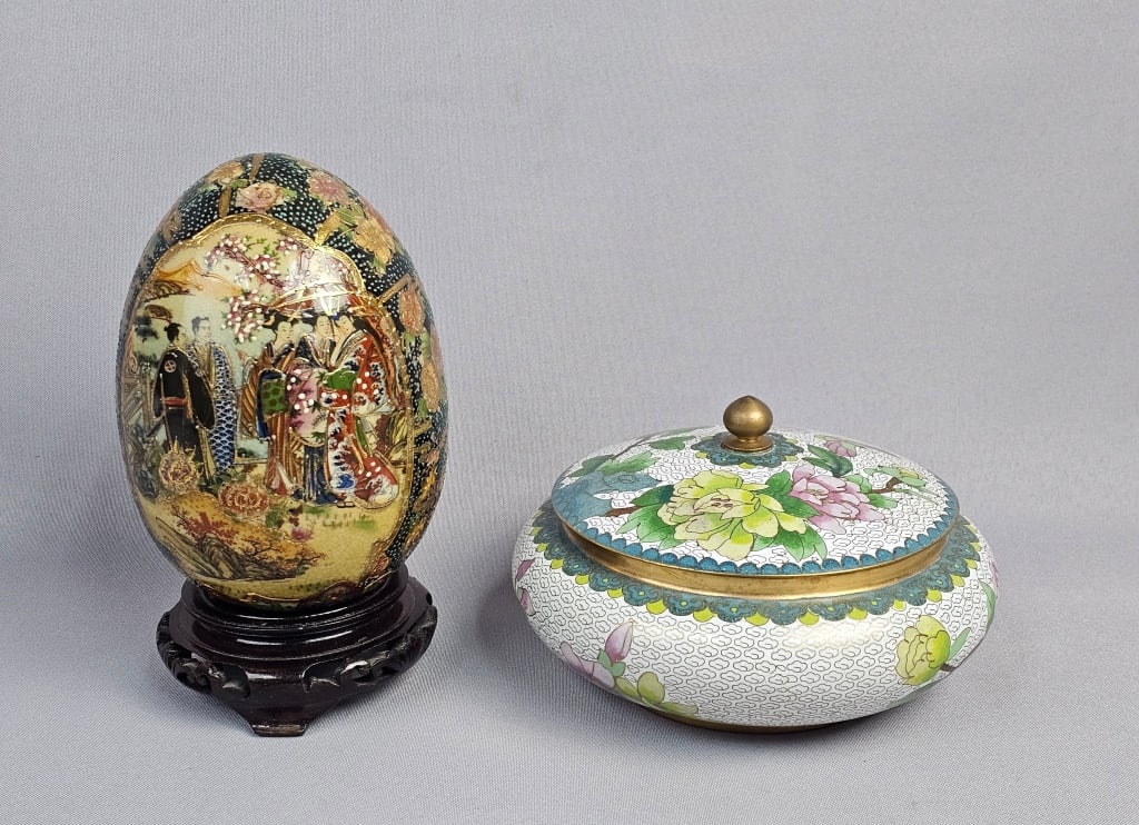 A Royal Satsuma Ceramic Egg on Stand and a Cloison: This lot comprises two decorative objects of East Asian origin. The first is a Royal Satsuma ceramic egg, hollow and ornamental, presented on a dark wooden display stand. It features intricate polychr