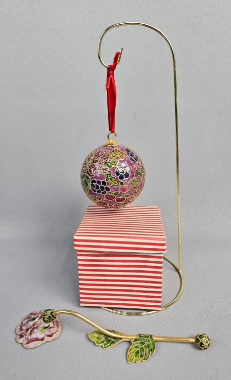 A Group of Decorative Objects including a Cloisonn: A group of decorative objects comprising a spherical ornament, a decorative stick, a small box, and a display stand. The spherical ornament features intricate multi-colored enamel work in a cloisonn&e