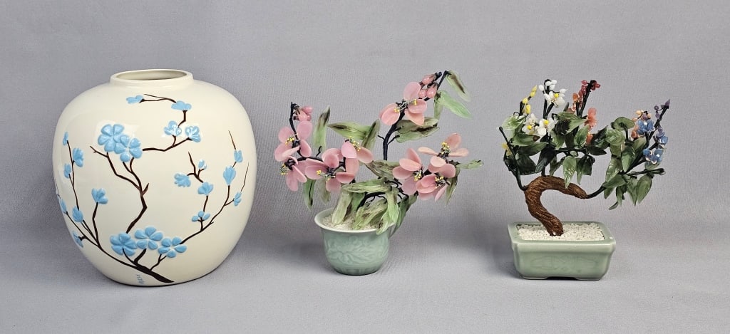 Three Decorative Ceramic and Hardstone Objects: This lot comprises three decorative objects: a globular ceramic vase and two artificial floral sculptures. The cream-glazed ceramic vase is adorned with raised light blue floral motifs and dark brown
