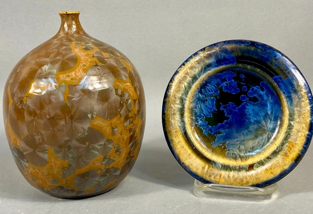 A Pair of Modern Studio Crystalline Glazed Pottery: A pair of modern studio pottery items featuring crystalline glazes. The first is a spherical vase with a narrow opening, presenting a rich brown and gold/orange ground adorned with a dense pattern of