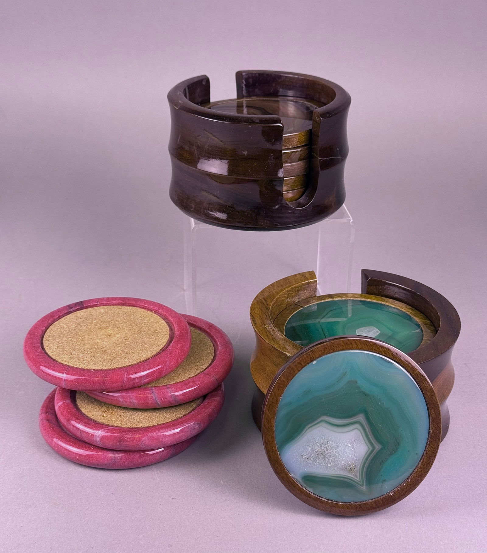 A Collection of Vintage Brazilian Agate and Stone Coasters with Holders: A collection of vintage Brazilian agate and stone coasters with accompanying holders. This lot comprises two sets of natural agate coasters. One set consists of six round polished slices in varying sh