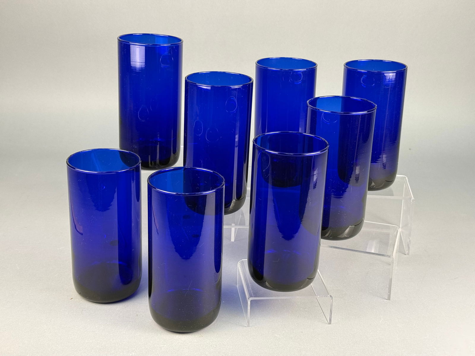 A Collection of Libbey Cobalt Blue Drinking Tumblers: A collection of drinking tumblers attributed to the manufacturer Libbey. The tumblers are crafted from heavy, deep cobalt blue glass in a Modern or Contemporary style. The set is composed of tumblers