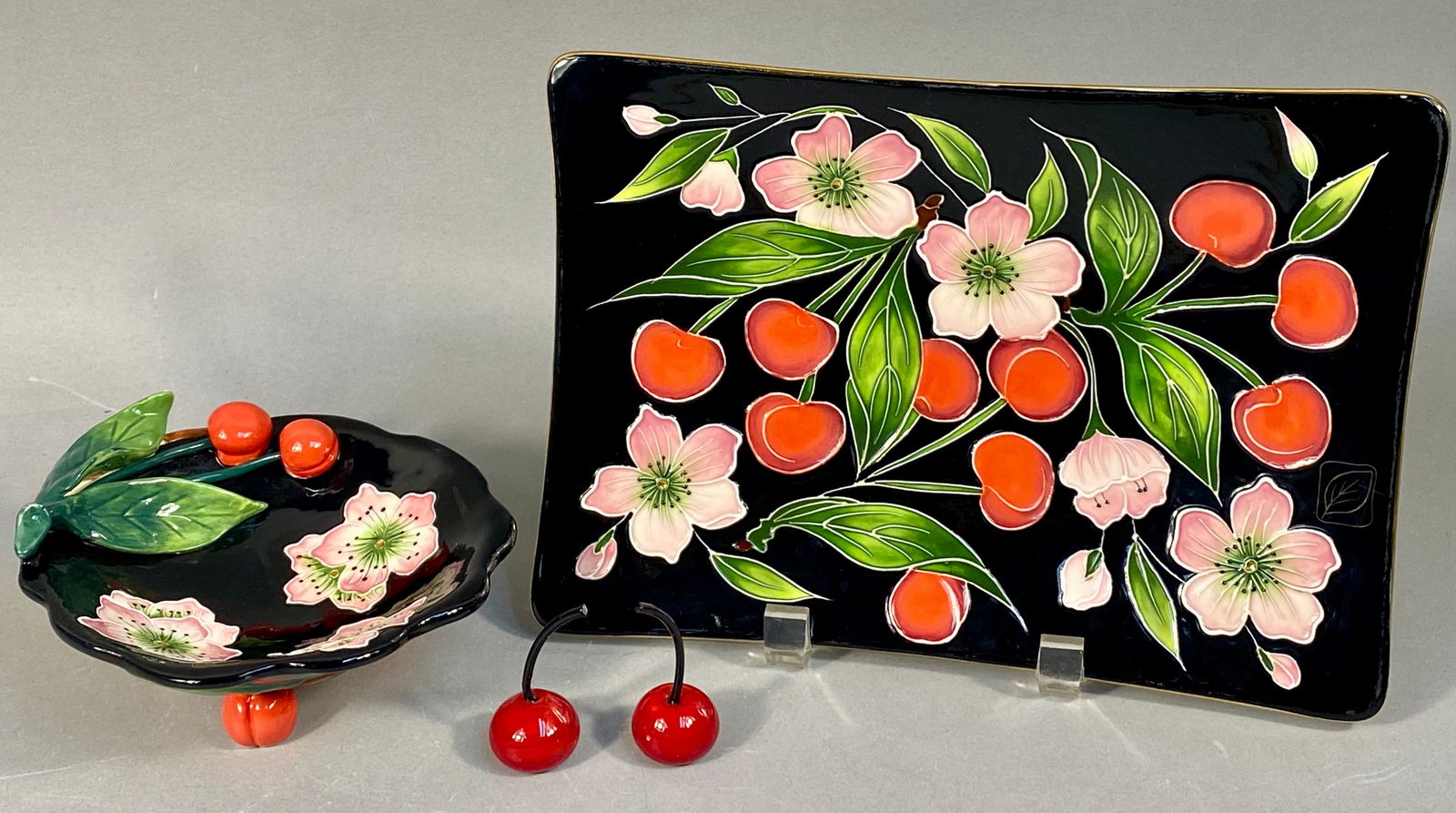 A Collection of Four J McCall Blue Sky Ceramic Cherry Blossom Items: A collection of four contemporary ceramic items designed by J McCall for Blue Sky Corp., dated 2004. The pieces feature a consistent, stylized botanical design utilizing dimensional, relief-molded dec
