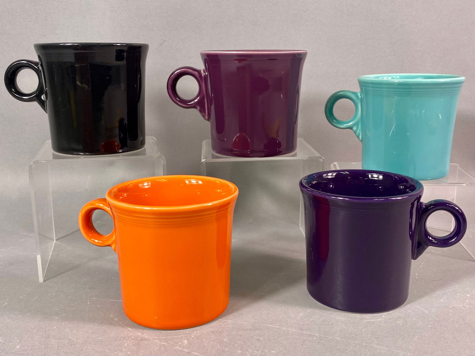 A Collection of 5 Homer Laughlin Fiesta Classic Ring Handle Mugs: A collection of five glazed ceramic coffee mugs manufactured by the Homer Laughlin China Company (HLC) in the popular Fiesta ware style. These are the Classic Ring Handle Mugs, commonly identified as