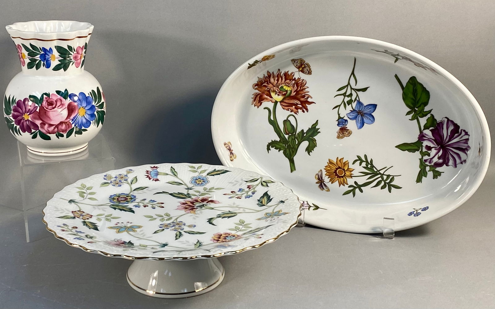 A Trio of Mixed Ceramic Tableware including BIA Cordon Bleu Caroline Oval Dish: A collection of three pieces of glazed ceramic and porcelain tableware from various makers. The lot includes one deep oval serving dish, one pedestal cake stand, and one bulbous vase. The oval dish is