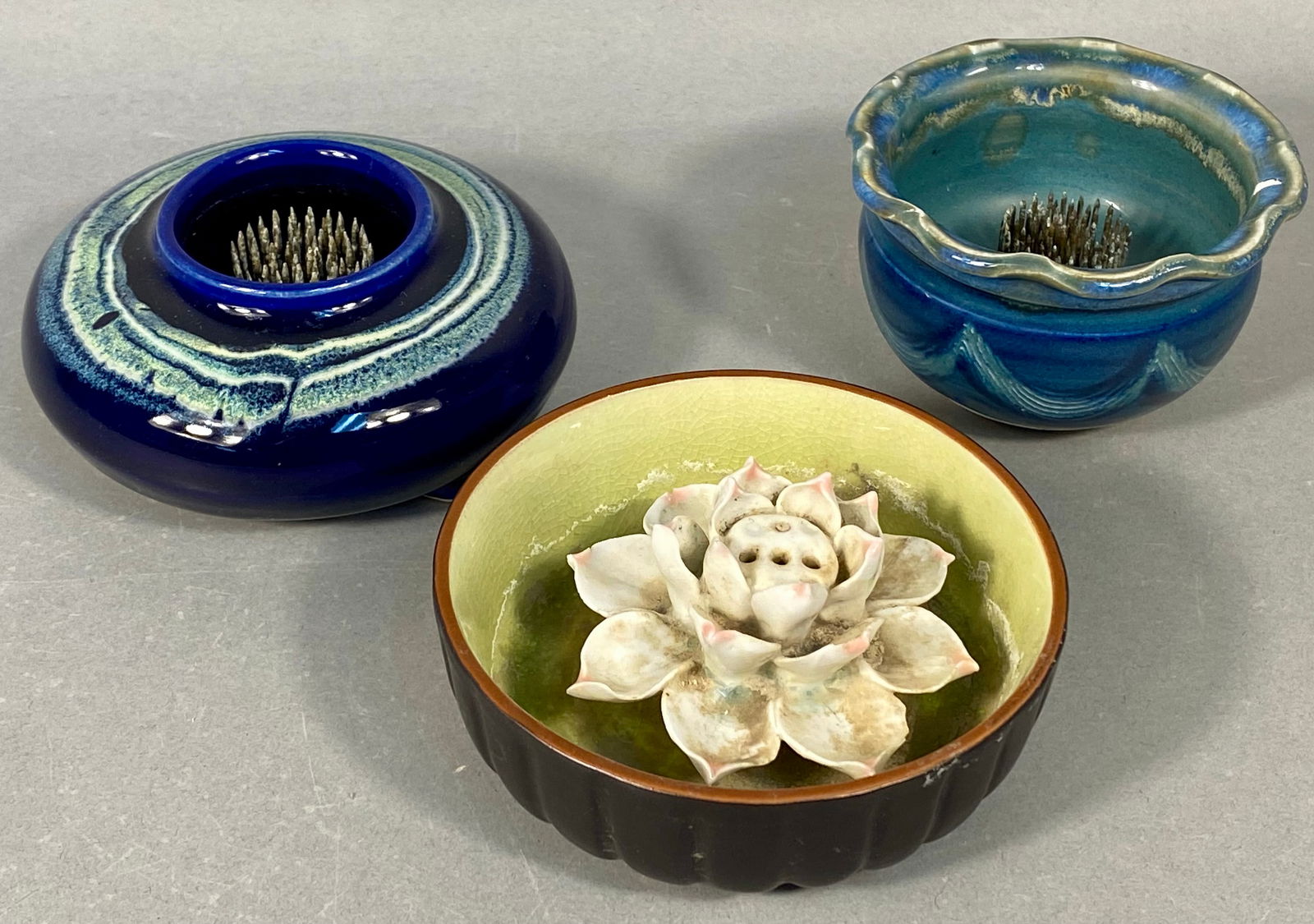 A Trio of Studio Pottery Ceramic froggers and Incense Holder: A collection of three contemporary studio pottery ceramic objects designed for floral arrangement (Ikebana) and incense burning. The collection includes two vessels featuring integrated metal kenzans