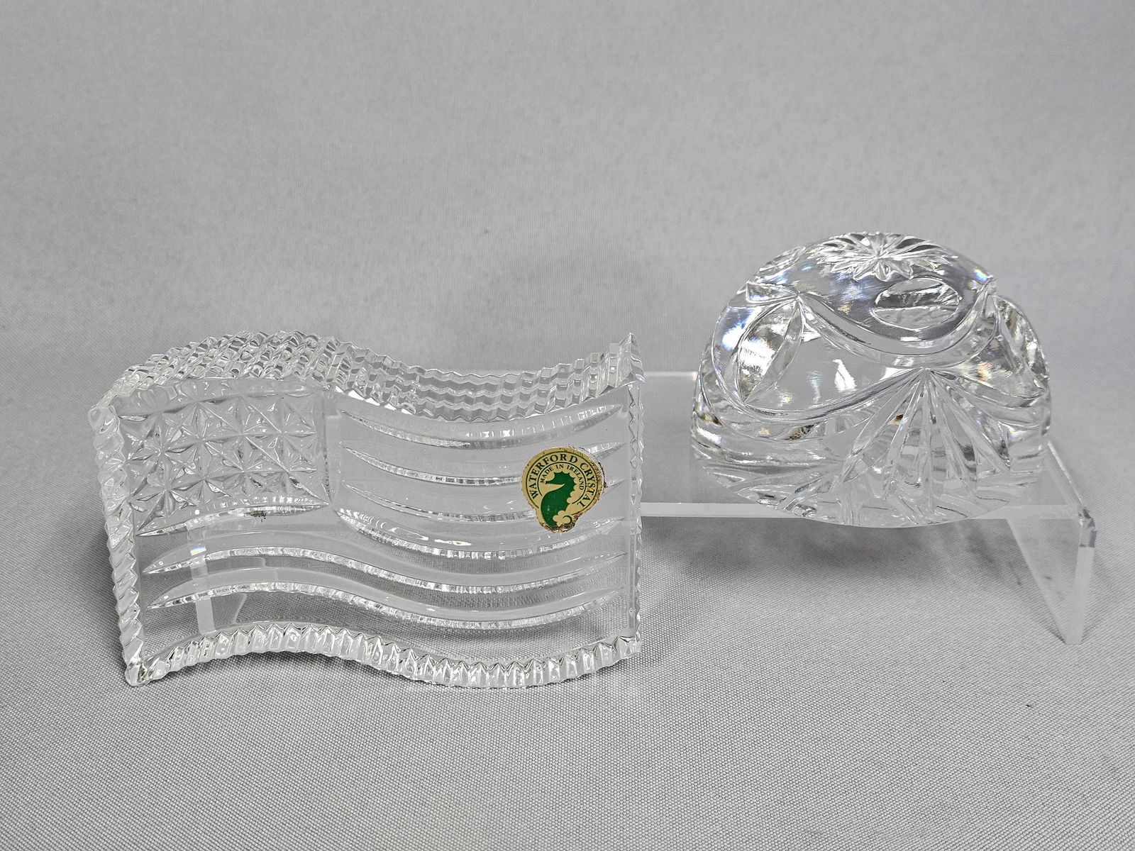 A Pair of Crystal Paperweights including Waterford American Flag and Goebel: A collection of two heavy cut crystal paperweights from different manufacturers. The first item, identified through markings as the Waterford Crystal Patriotic American Flag Paperweight, is a sculptur