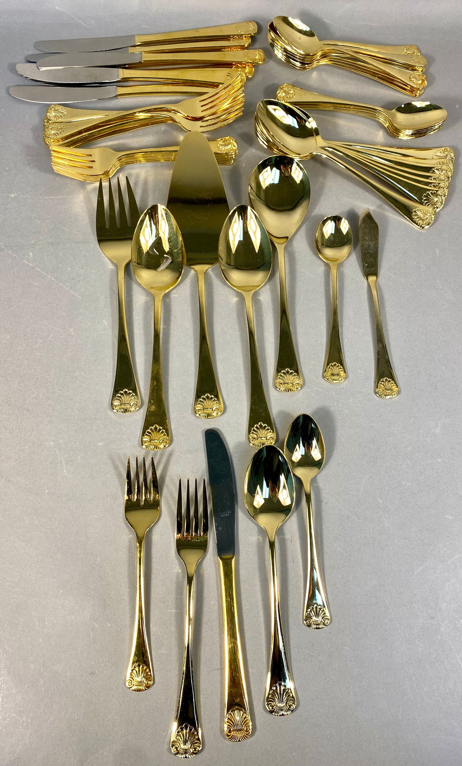 A Collection of 54 Pieces of Gold Electroplated Stainless Steel Flatware in the Shell Pattern, (1 of 5)