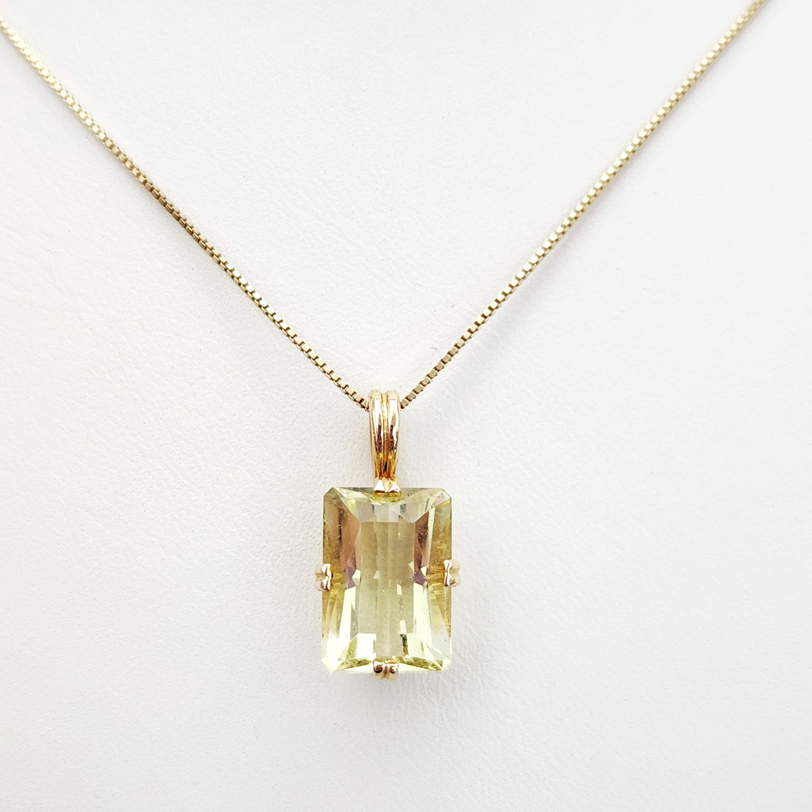 14K Gold Lemon Quartz Necklace 4.8 Grams: This contemporary necklace features a emerald-cut lemon quartz pendant suspended from a 14K yellow gold box chain. The gemstone is secured in a four-prong open basket setting. The chain is equipped wi