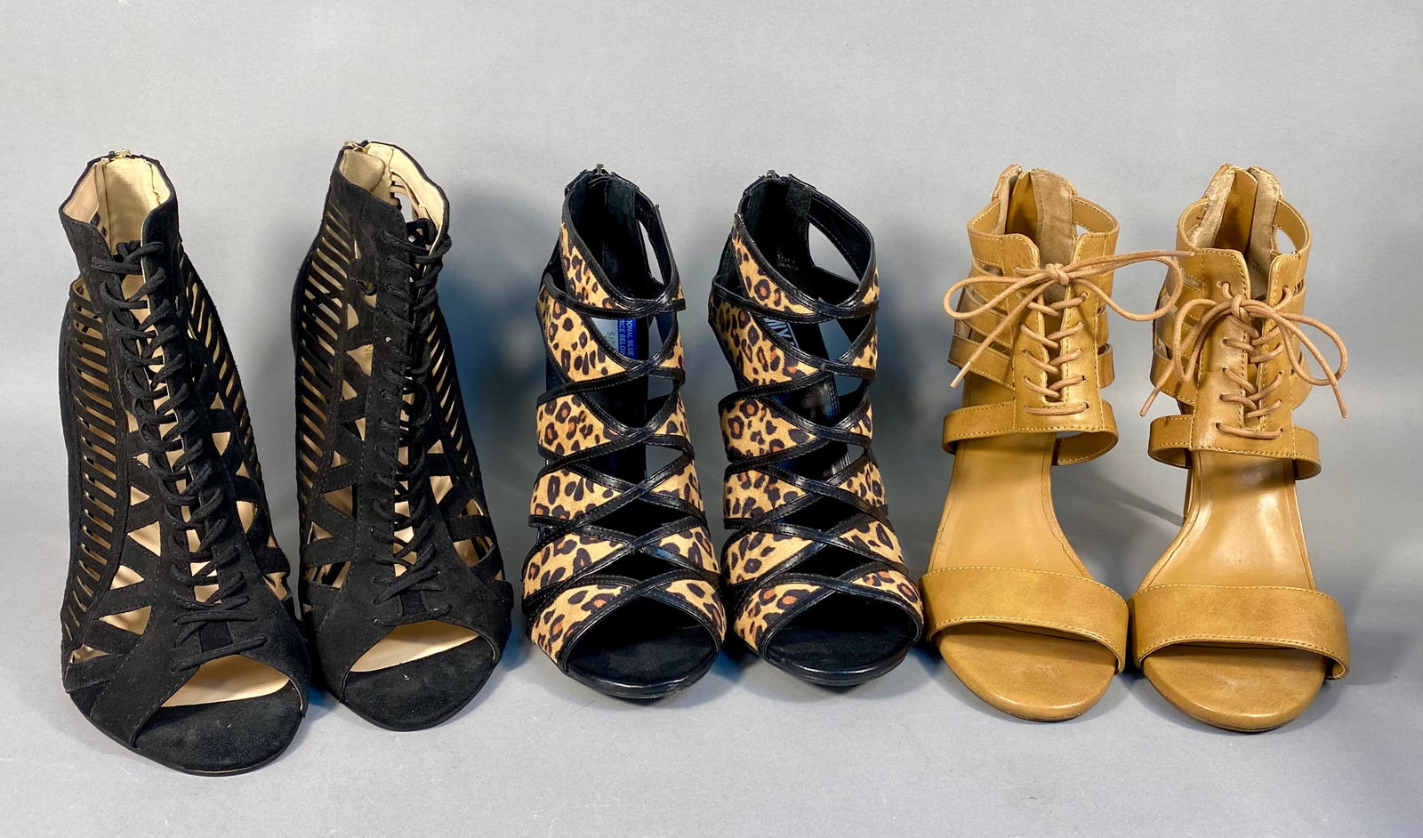 Three Pairs of Women's High-Heeled Cage Sandals including Nine West and Report Signature: A trio of women's high-heeled cage sandals, all size 10. The group includes a pair of Nine West black suede-like stiletto sandals featuring an intricate caged design with a lace-up front and gold-tone