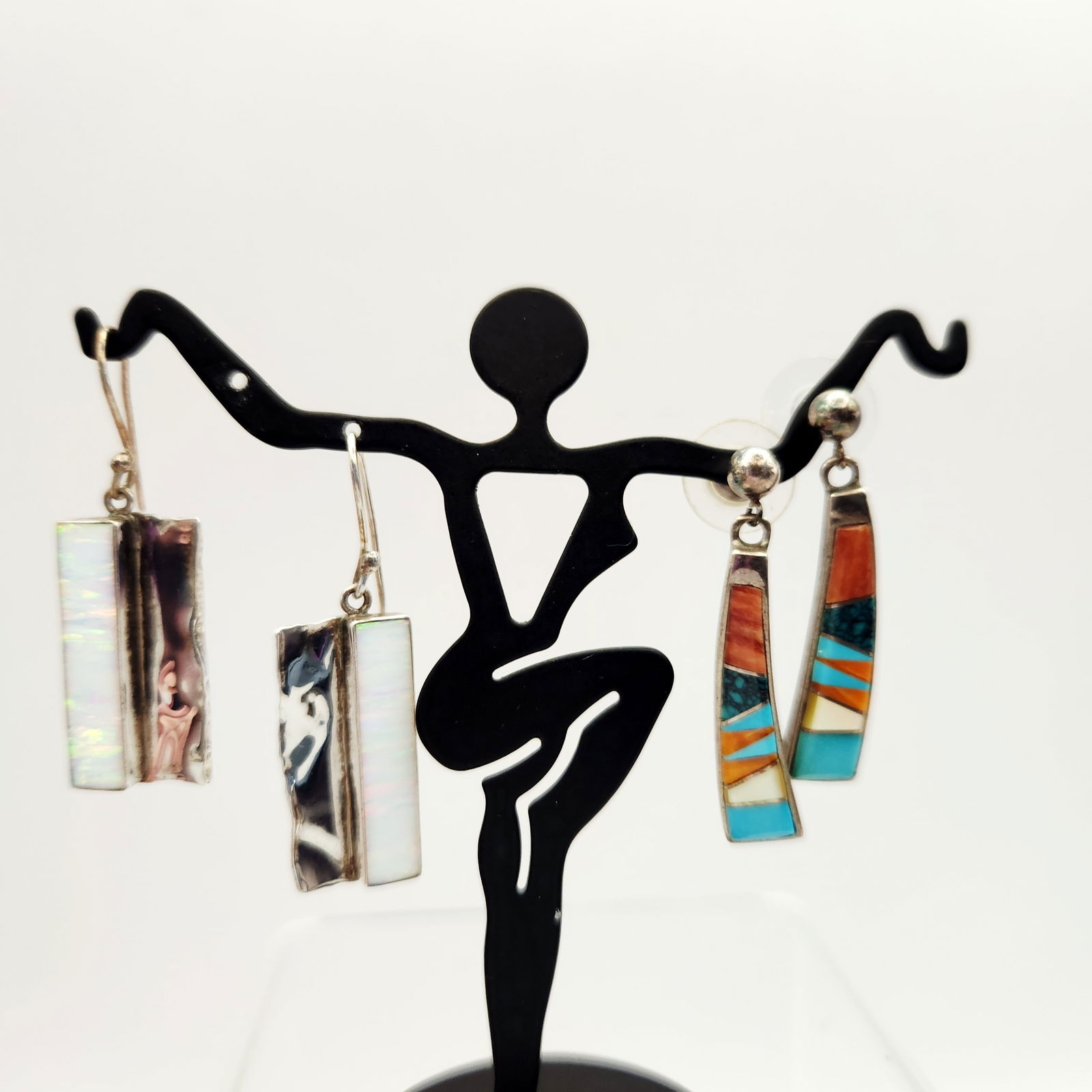 Sterling Silver Earrings 12.5 Grams: A collection of four sterling silver earrings forming two distinct pairs. The first pair consists of tapered drop earrings executed in the Southwestern style, featuring intricate channel inlay work. T