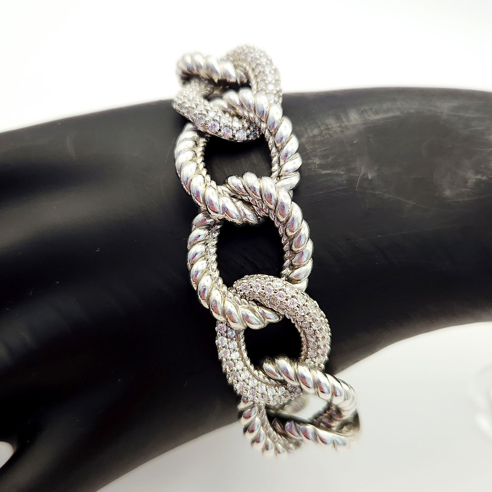 Judith Ripka Sterling & CZ Bracelet: A Judith Ripka designer link bracelet crafted from 925 sterling silver. The design features oversized, interlocking oval links in an alternating sequence of textured twisted rope links and links pav&e