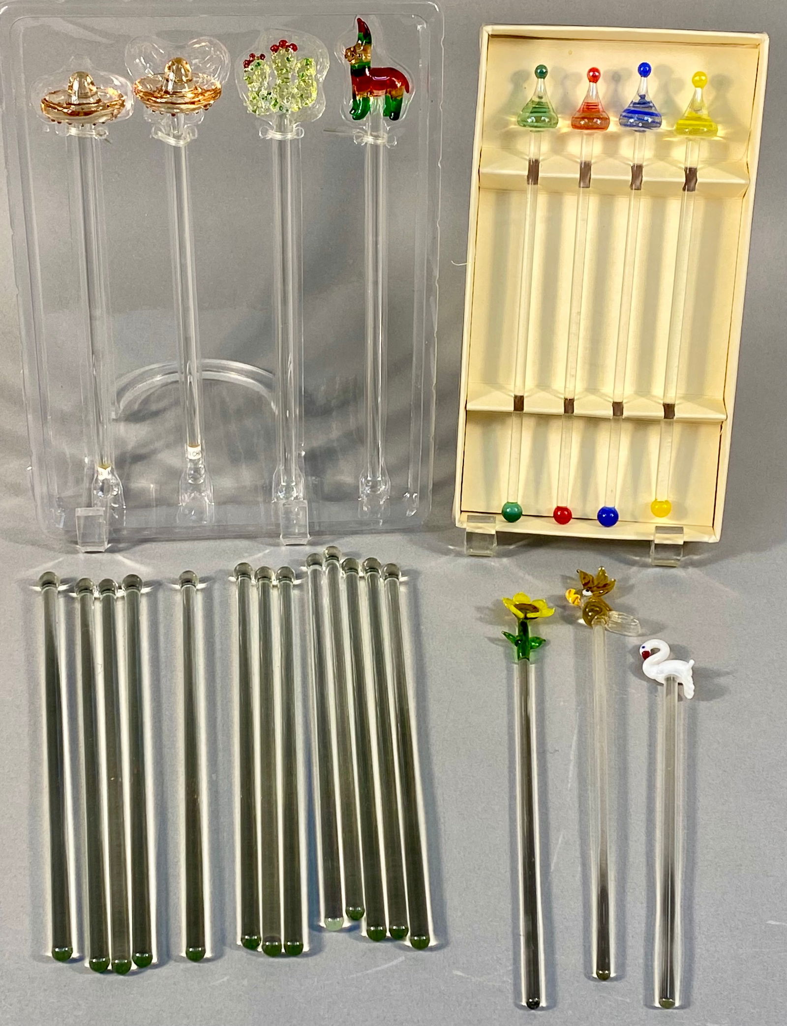A Collection of 24 Lampwork Glass Cocktail Stirrers: A large collection of 24 contemporary cocktail stirrers or swizzle sticks, attributed to the style of Pier 1 Imports barware. The collection is fabricated from clear lampwork glass stems with various