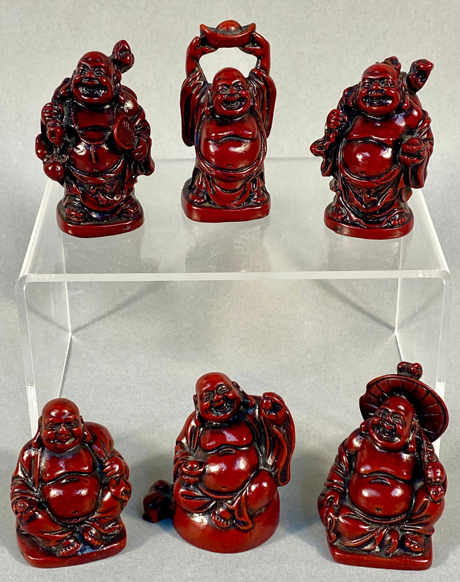 A Collection of Red Resin Traveling Laughing Buddha Figurines (1 of 10)