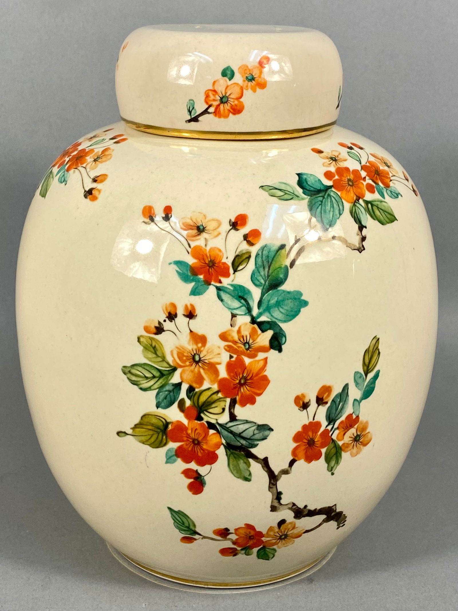 A Hyalyn Ceramic Lidded Ginger Jar Model 824: A Hyalyn ceramic lidded ginger jar, model number 824, produced in the USA. The ovoid vessel is finished in a speckled cream glaze and decorated with a floral motif featuring orange and yellow blossoms