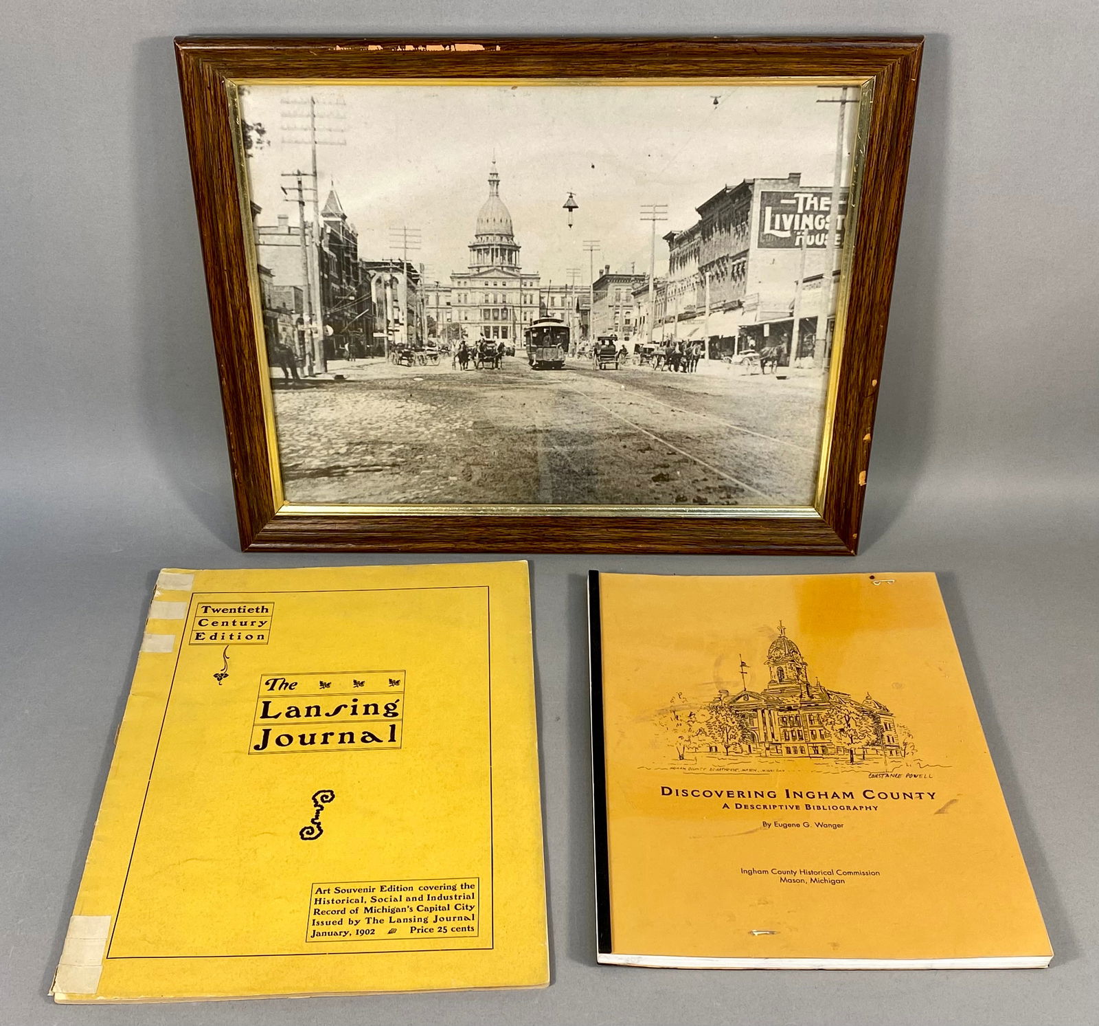 A Trio of Lansing and Ingham County Historical Ephemera: A trio of historical items including a framed print of Michigan Avenue, Lansing. The collection documents the heritage of Lansing and Ingham County, Michigan, featuring a framed black and white print