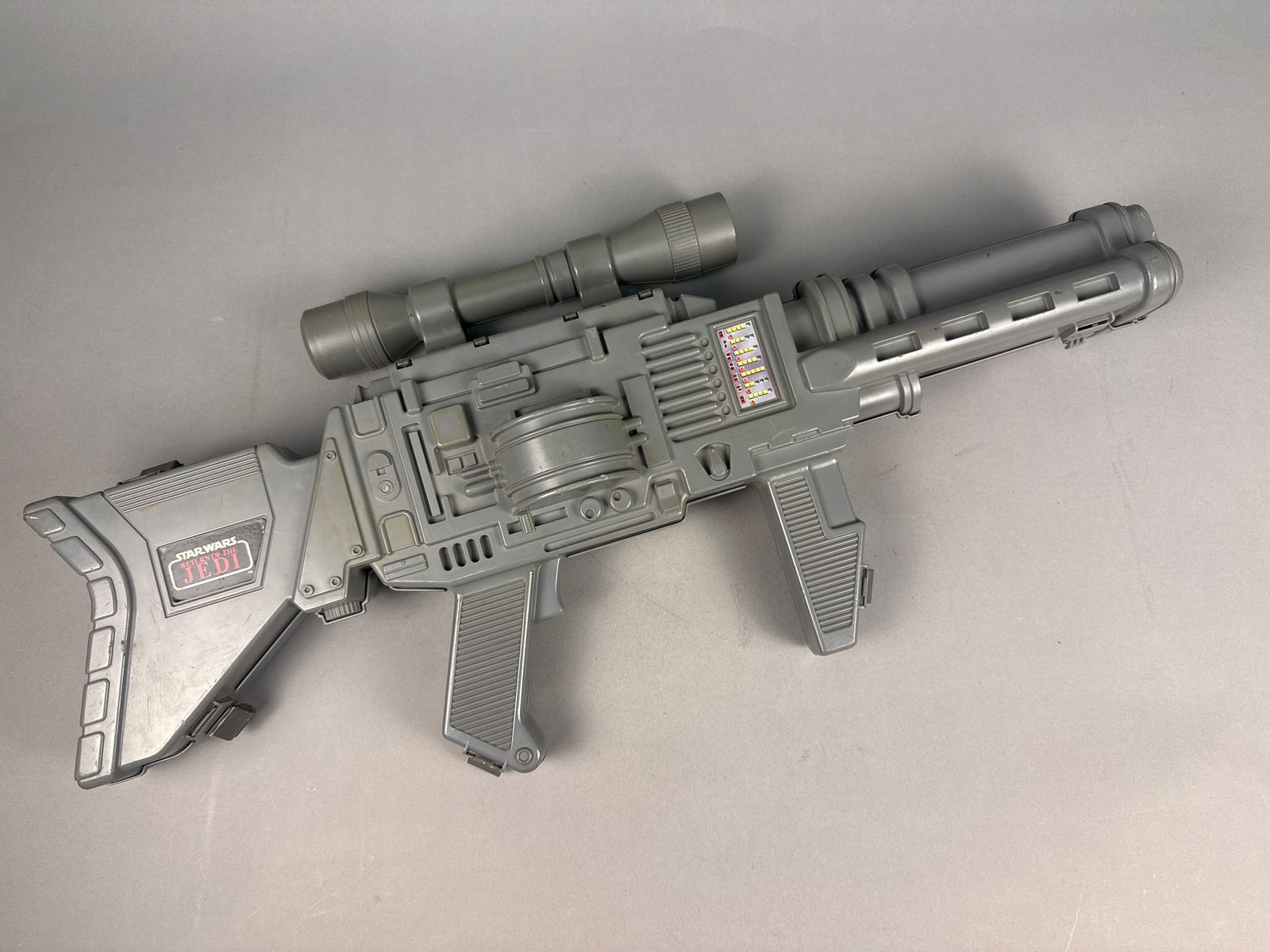 1984 Kenner Star Wars Return of the Jedi Laser Rifle Carry Case: This 1984 Kenner Star Wars Return of the Jedi Laser Rifle Carry Case is a large-scale toy blaster and action figure storage unit. Constructed from grey molded plastic, the item features a top-mounted
