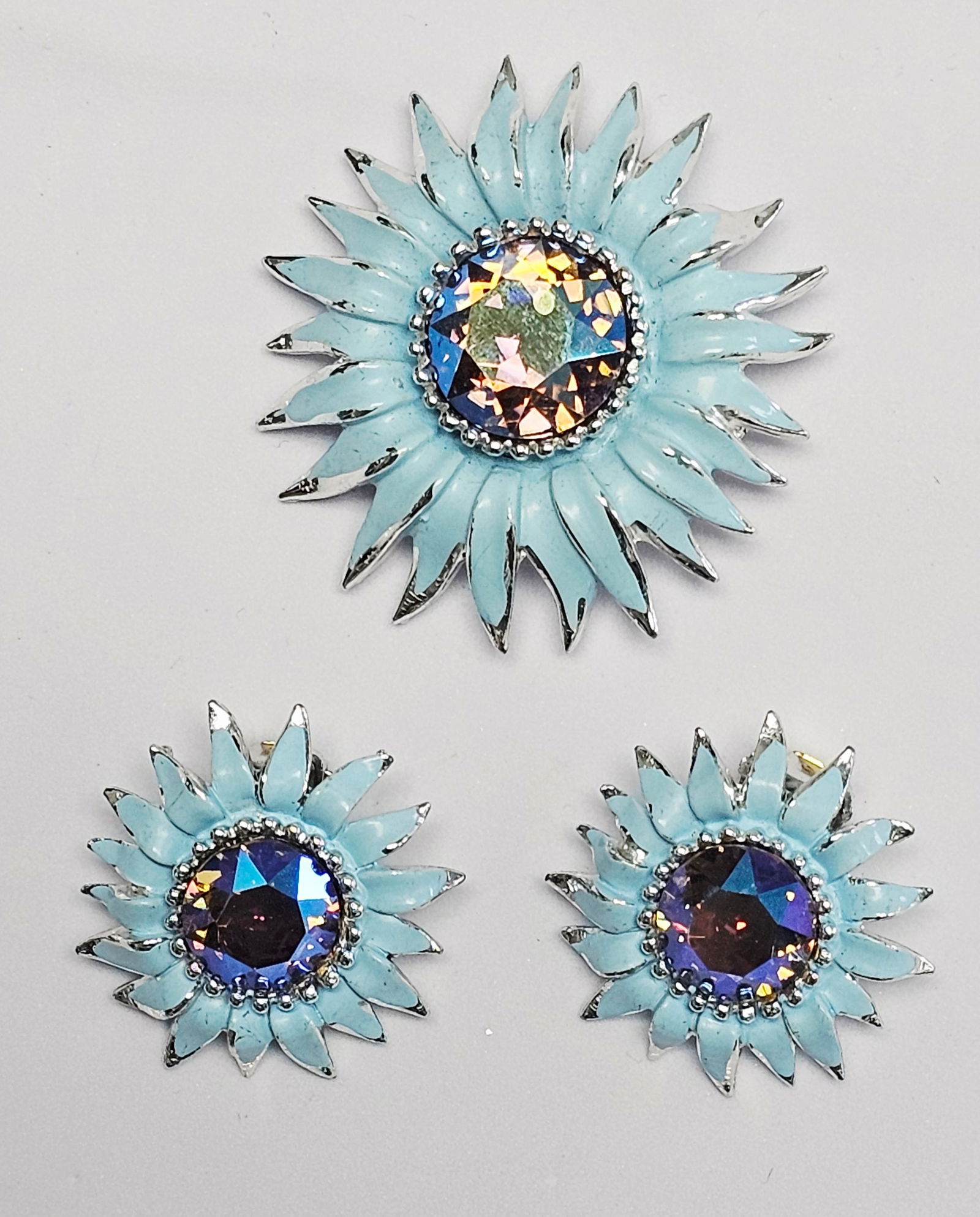 Weiss Enamel and Aurora Borealis Rhinestone Brooch & Earrings: A trio of vintage costume jewelry pieces by Weiss featuring a floral sunflower design. The collection includes a circular brooch and a pair of clip-on earrings. Each piece is constructed from silver-t