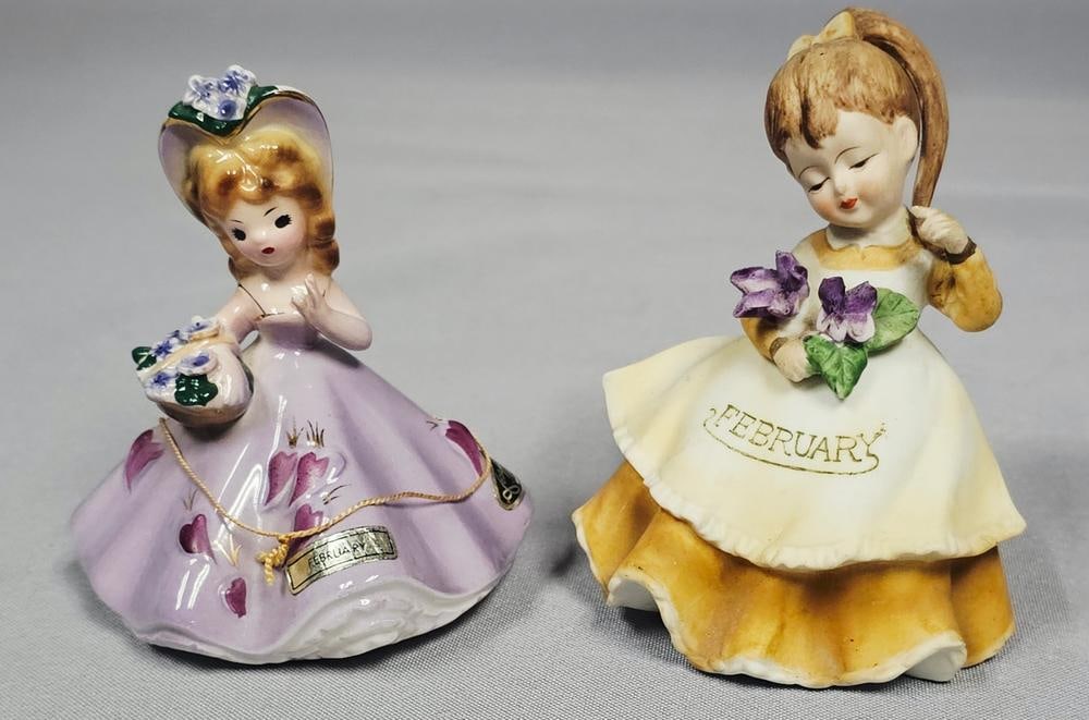A Pair of Mid-Century Ceramic February Birthday Girl Figurines by Lefton and Josef Originals: Two mid-century ceramic figurines representing the month of February. The first is a bisque porcelain figurine by Geo. Z. Lefton, model KW4200, from the Girl of the Month series. It depicts a girl in
