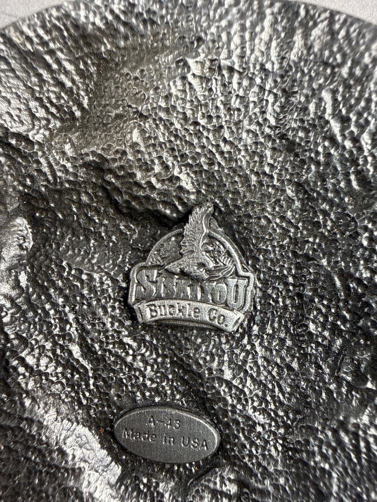 Siskiyou Buckle Co. Colorado State Pewter Eagle Belt Buckle: Manufactured by the Siskiyou Buckle Co., this oval pewter-alloy belt buckle features a relief scene of an eagle in flight carrying a fish. The design is set against a mountain backdrop with Colorado