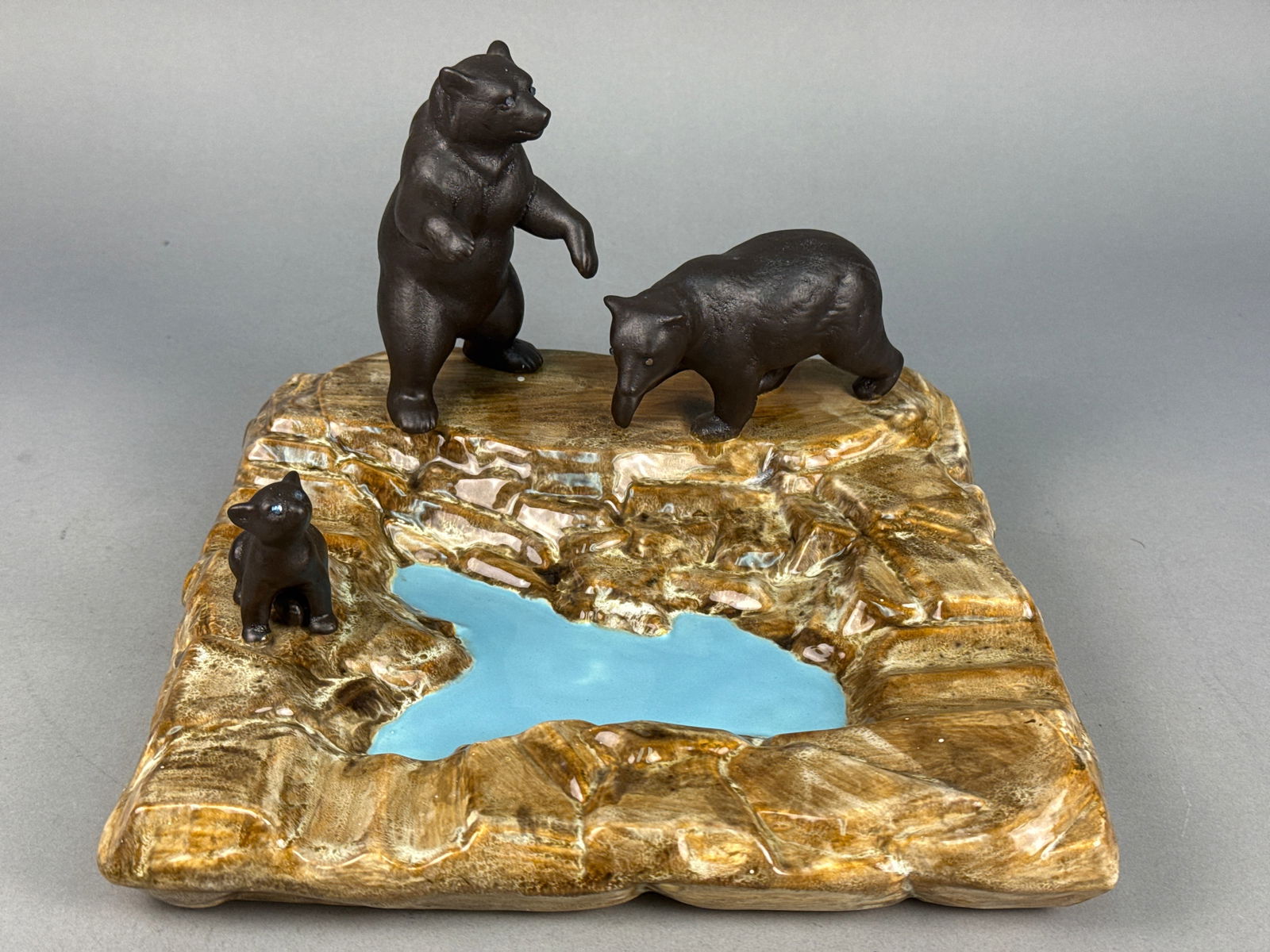 Vintage Bear Fishing for Salmon Ceramic Platter: This vintage ceramic Plate/dish features a wildlife diorama of a grizzly bear fishing scene. The piece includes a trio of bears, including a standing adult, a walking adult, and a seated cub, situated