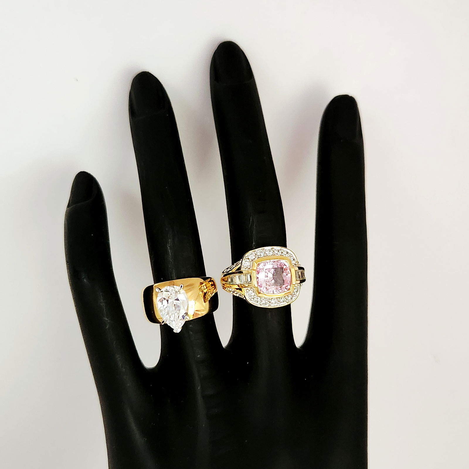 Vermeil Synthetic Stone Rings 12.9 Grams: This lot features two rings crafted from gold over sterling (Vermeil), both bearing 925 hallmarks. The first ring is designed with a wide, polished band set with a large, faceted pear-cut clear stone