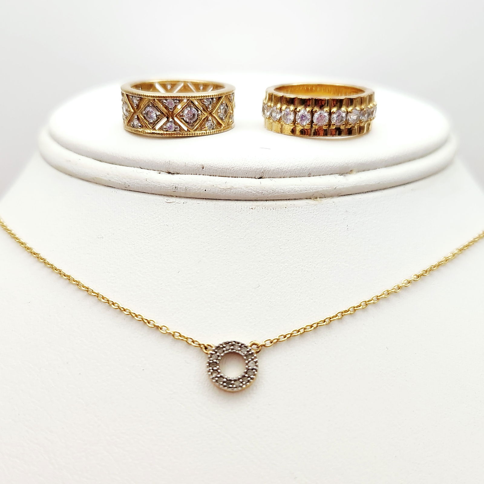 Trio of Vermeil Cubic Zirconia Jewelry 11.5 Grams: A trio of jewelry items composed of gold over (vermeil) sterling silver set with clear cubic zirconia accents. The collection consists of a necklace and two band rings. The necklace features a fine ca