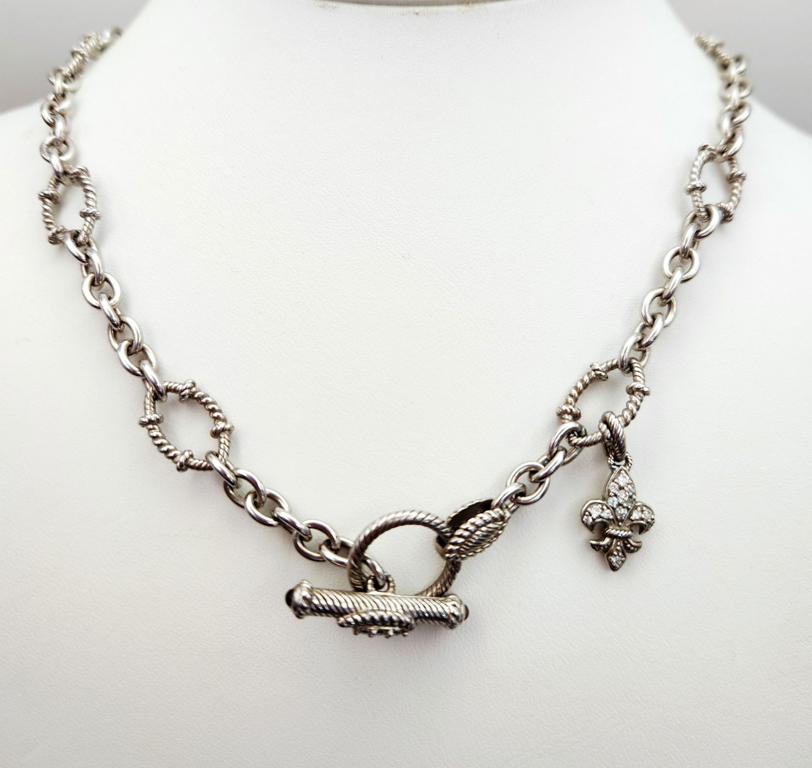 Judith Ripka Sterling Necklace 39.2 Grams: A Judith Ripka sterling silver fleur-de-lis necklace featuring a chunky chain composed of alternating polished and rope-textured oval links. The piece is secured by an ornate toggle clasp embellished