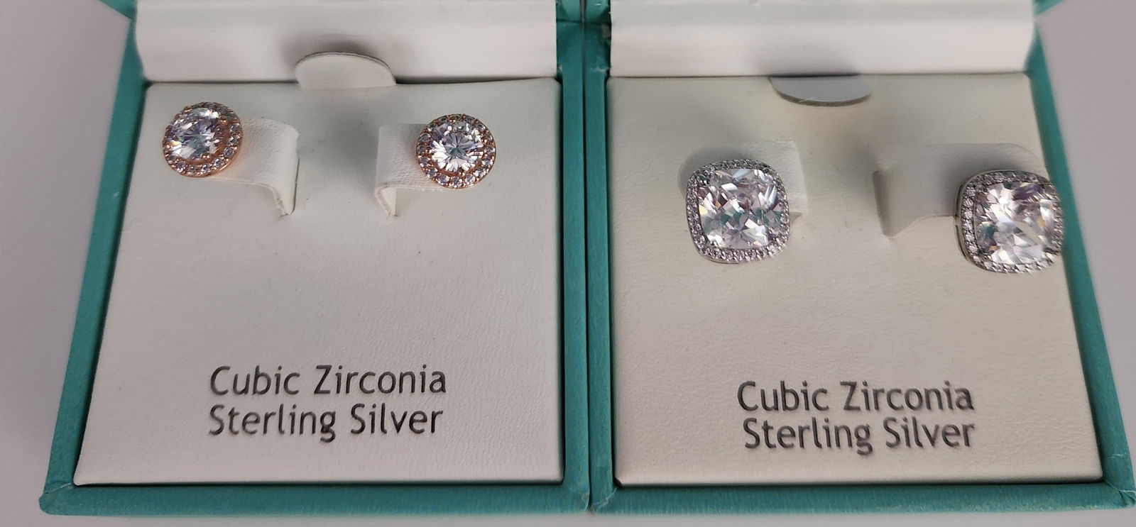 Nanette Lepore Sterling & CZirconia Earrings 6.8 Grams: A collection of two pairs of contemporary stud earrings by Nanette Lepore. The first pair features round-cut cubic zirconia center stones within a halo of smaller stones, set in rose gold-plated