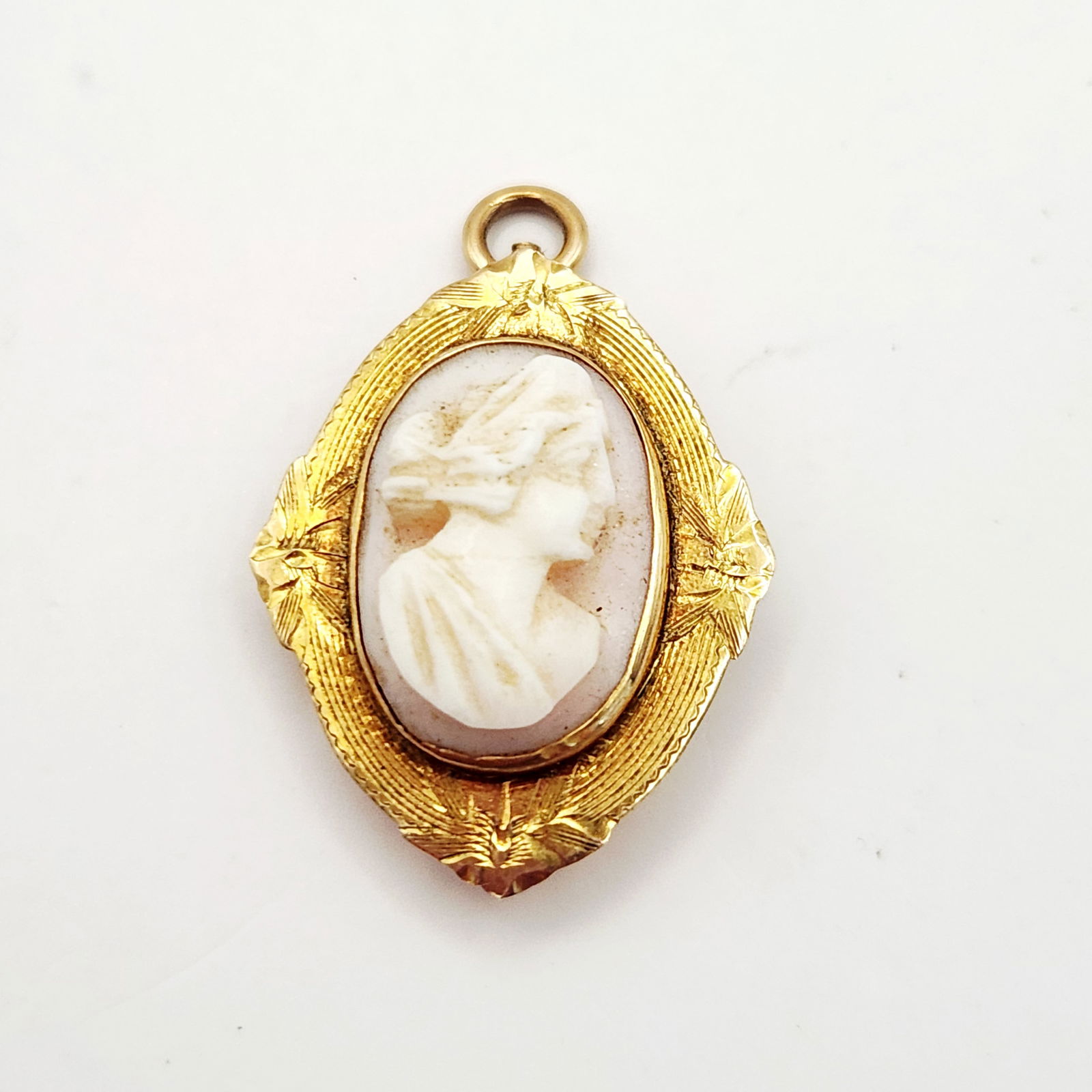 Victorian Shell Cameo Brooch Pendant: This Victorian-style shell cameo brooch and pendant combination features an oval carving of a womanâ€™s profile in relief, set against a natural pinkish background. The carving is housed in an