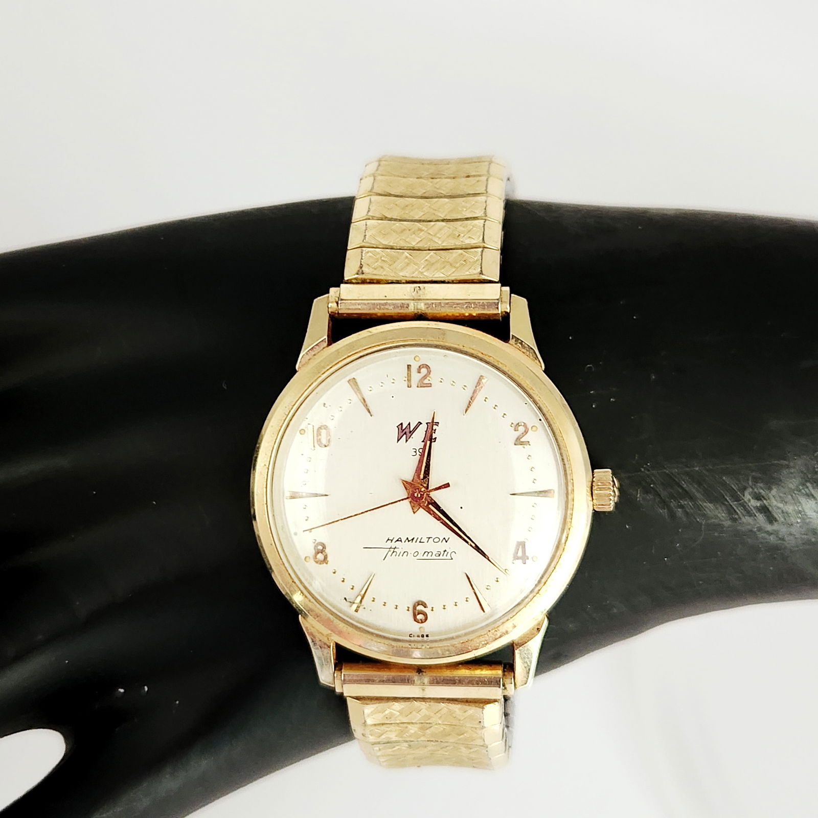 Hamilton Thin-O-Matic 14kt Yellow Gold Men's Watch: A vintage Hamilton Thin-o-matic wristwatch featuring a 14kt yellow gold case. The timepiece is paired with a gold-tone Speidel expansion band. The silver-tone textured dial is detailed with gold-tone