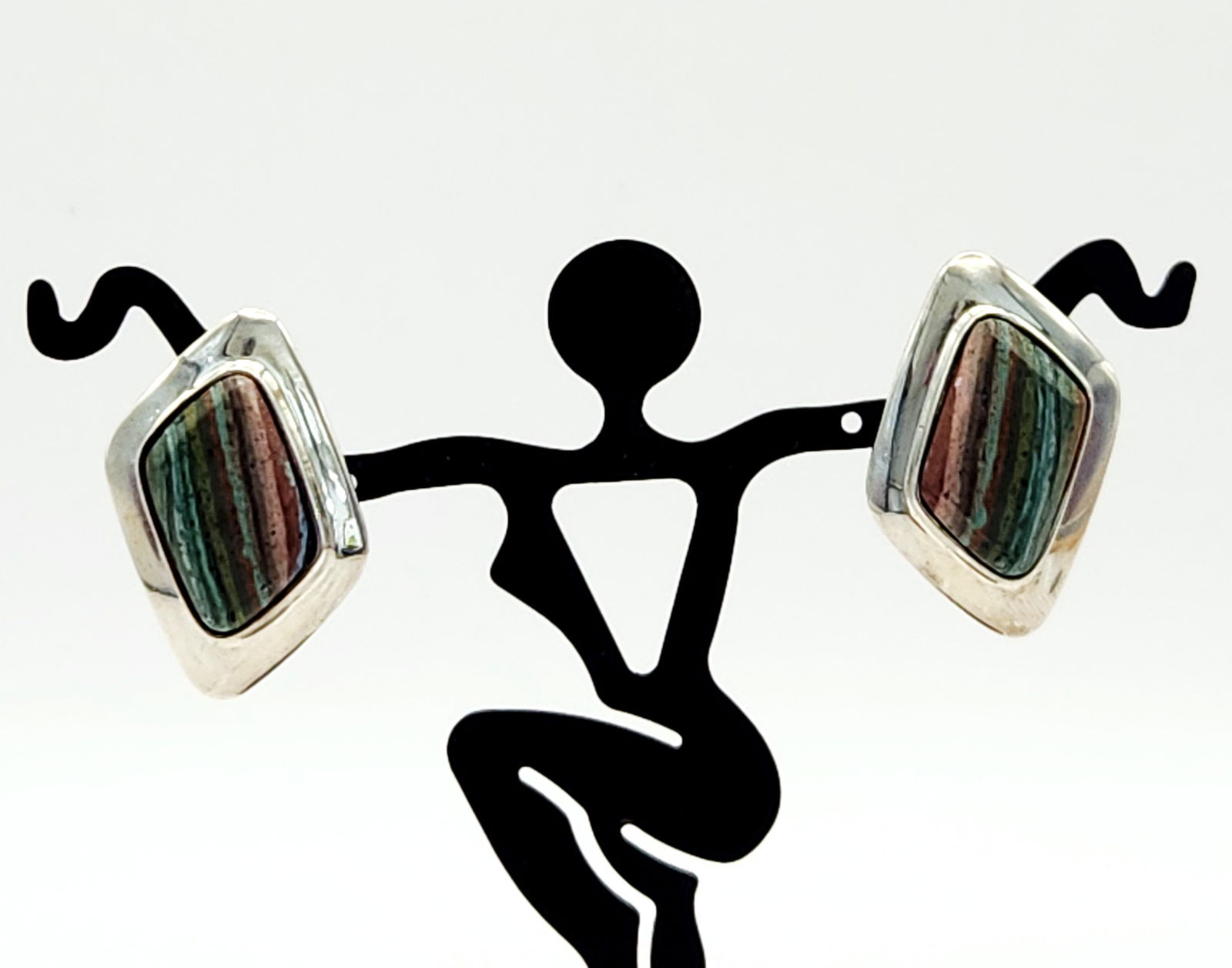 Sterling Polychrome Jasper Earrings 10 Grams: A pair of Desert Rose Trading sterling silver stud earrings of modern lozenge-shaped design. Each earring features an inlaid multicolored stone with horizontal striations in shades of red, green,