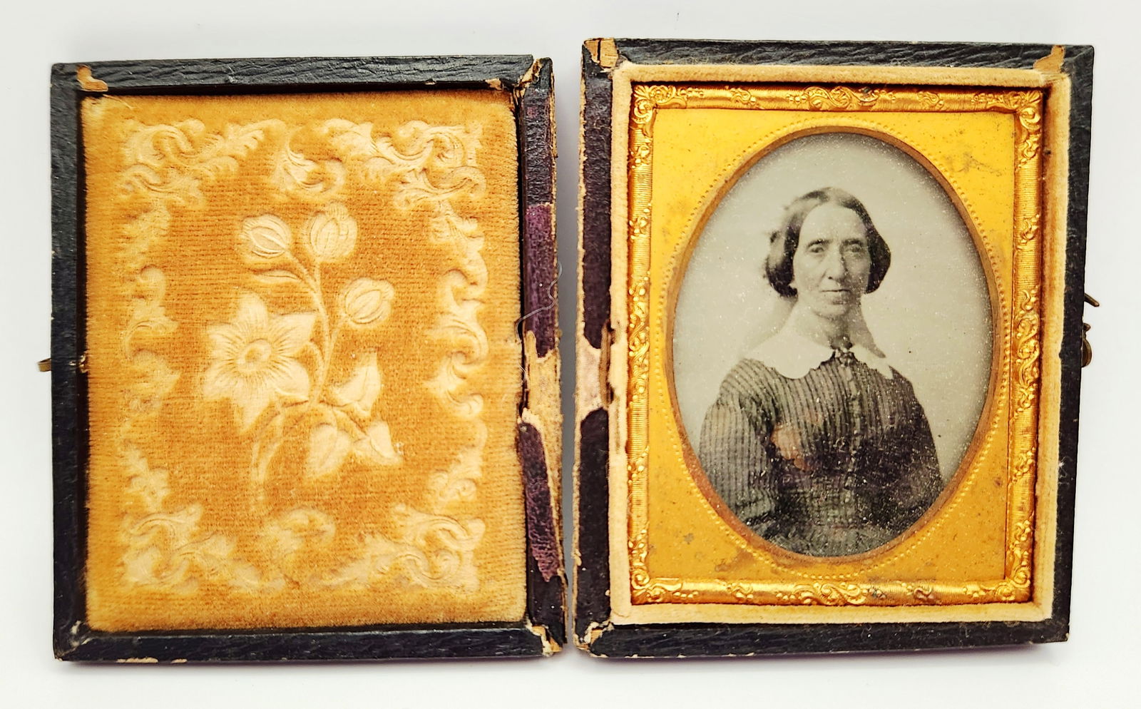 Antique Cased Daguerreotype Portrait of a Woman: This mid-19th century monochrome photographic portrait, likely a daguerreotype or ambrotype, depicts a woman with dark hair in a center part wearing a striped dress with a white collar. The image is