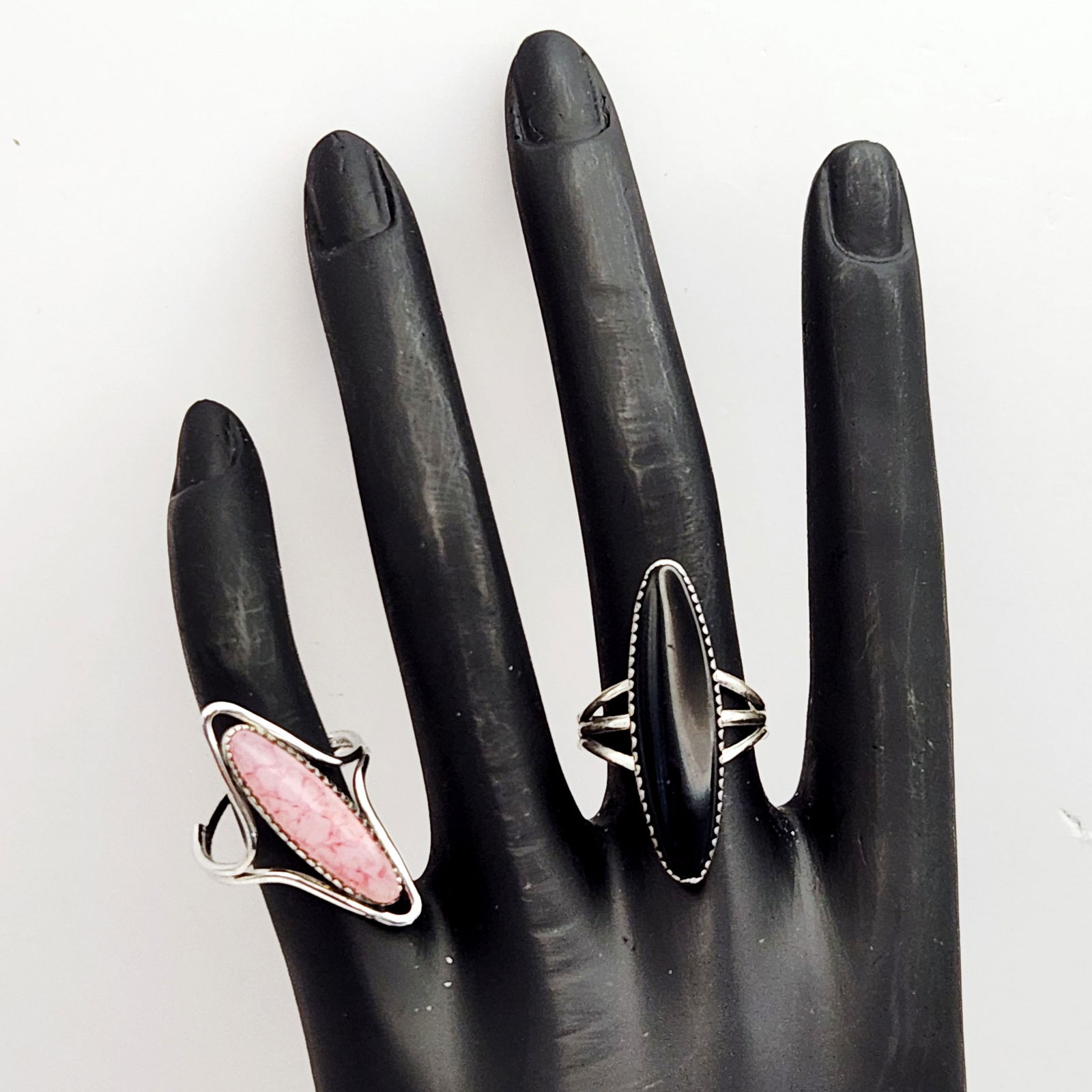 Beau Sterling & Stone Rings 7.6 Grams: Two sterling silver rings by Beau Sterling, each featuring an elongated marquise-shaped cabochon set in a serrated bezel. One ring is set with a dark, banded semi-precious stone on a triple-split shan