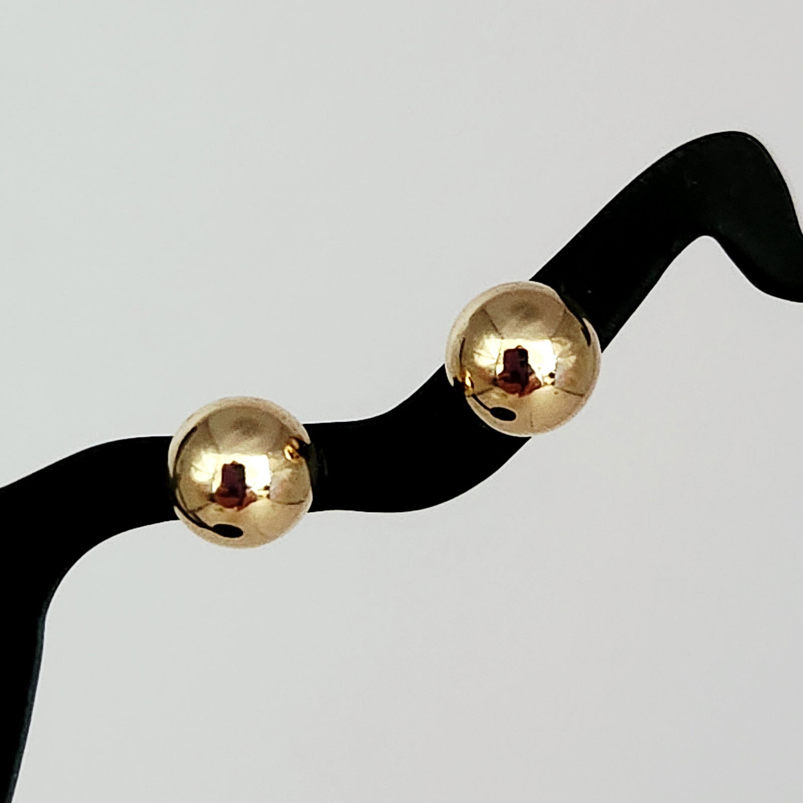 14K Gold Ball Stud Earrings 0.4 Grams: A pair of 14K yellow gold ball-style stud earrings featuring a high-polish finish. Each earring consists of a spherical bead mounted on a straight post, accompanied by matching butterfly friction back