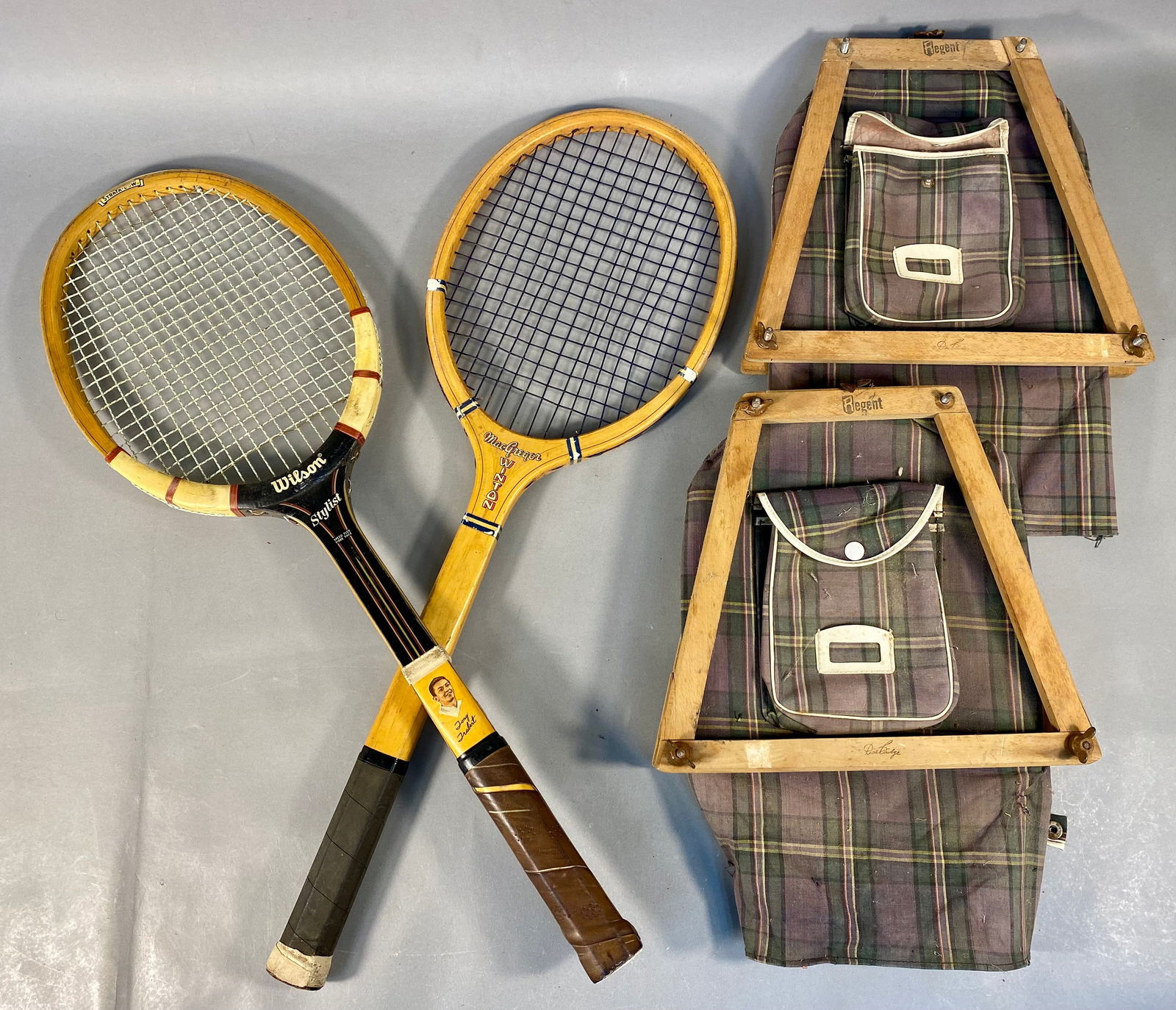 A Collection of Vintage Wooden Tennis Rackets and Regent Brand Accessories: This collection includes three vintage and antique wooden tennis rackets and coordinating protective equipment. Featured is a Wilson Stylist Tony Trabert signature model constructed with a multi-ply S