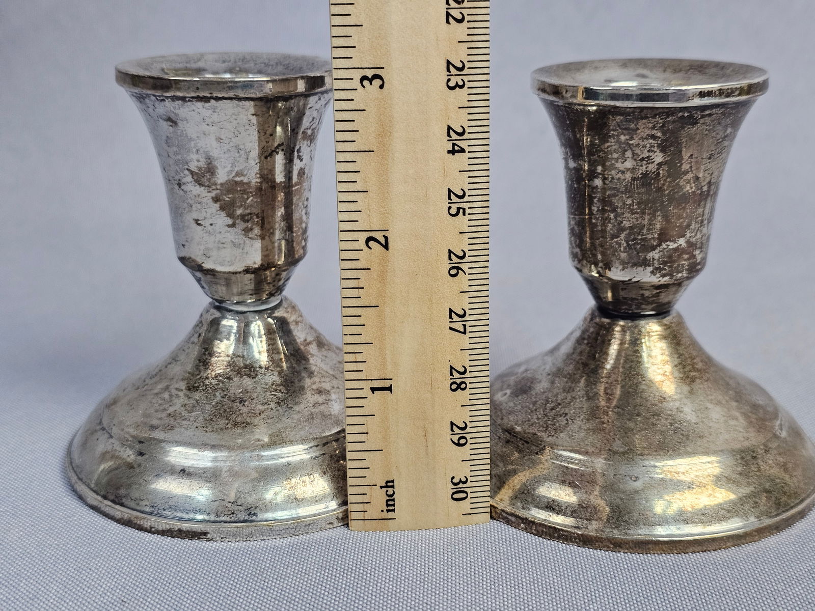 A Pair of Duchin Creation Weighted Sterling Silver Candlesticks: A pair of weighted sterling silver candlesticks by Duchin Creation. Each piece features a mid-century design consisting of a flared cup mounted on a weighted conical base. The undersides are stamped