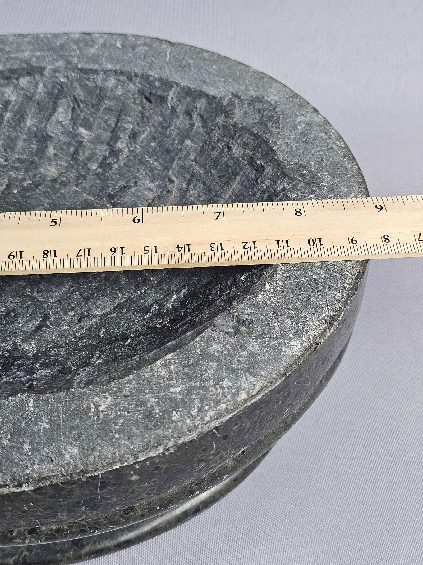 A Dark Green Stone Mortar Bowl: A circular footed pedestal bowl crafted from a dark, mottled green stone with black inclusions, likely marble or serpentine. The piece features a smooth, polished exterior and a shallow, roughly hand-