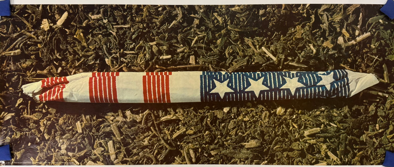 A Vintage 1971 Counterculture Poster Distributed by Synergisms San Francisco: This vintage 1971 counterculture poster features a photographic image of a large, hand-rolled cigarette wrapped in American flag-themed paper, resting on a bed of dried plant material. The poster is p