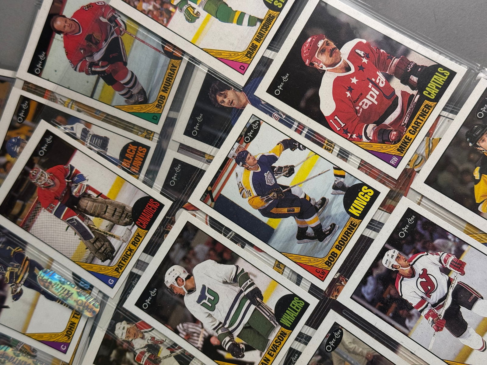 A Collection of 1987 O-Pee-Chee NHL Hockey Trading Cards: A collection of 1987 O-Pee-Chee hockey trading cards featuring various players from the National Hockey League. The collection is housed within clear plastic Ultra PRO nine-pocket protector sheets. 
