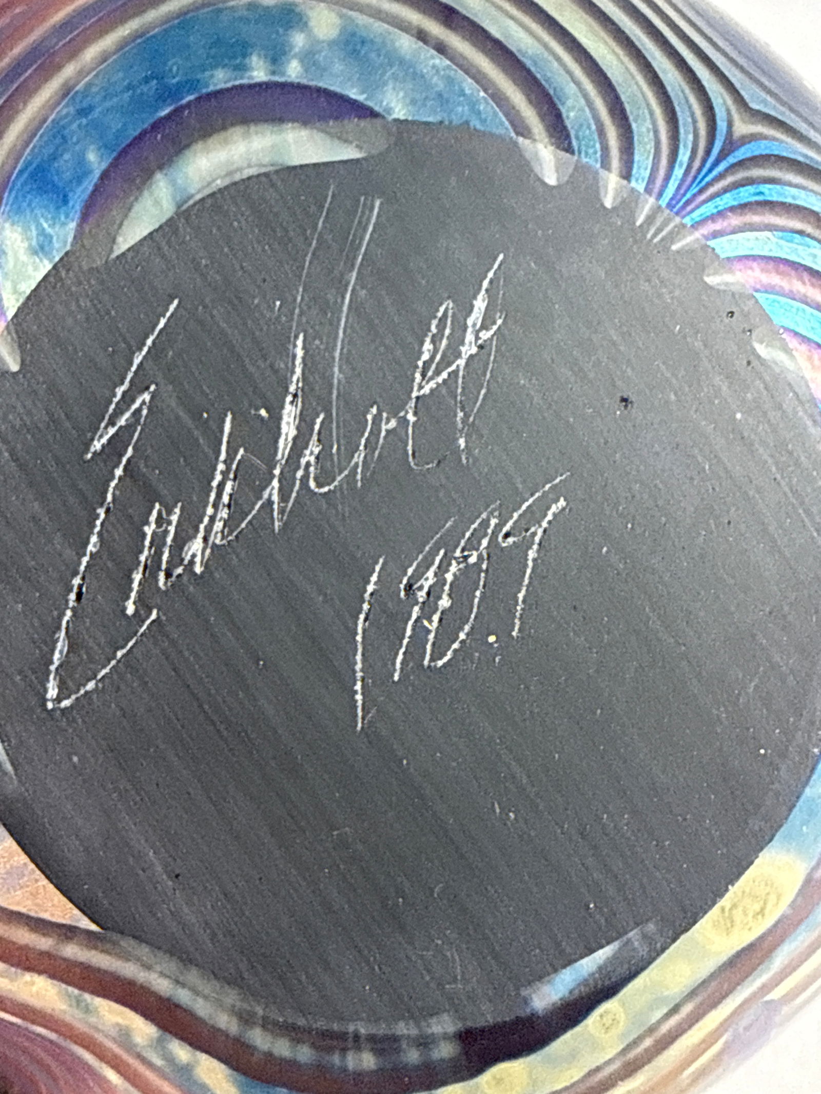 Robert Eickholt Iridescent Pulled Feather Art Glass Paperweight: A spherical art glass paperweight by Robert Eickholt featuring an iridescent pulled feather and swirl pattern in shades of blue, green, and gold. The piece is finished with a metallic luster across