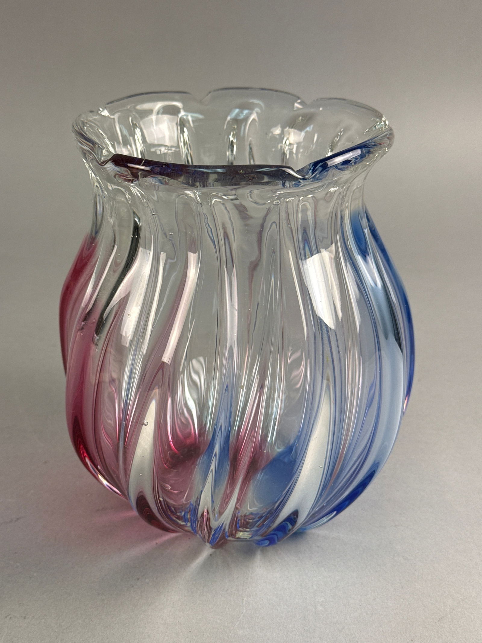 Sanyu Glass Japan Fantasy Art Glass Vase: A hand-blown art glass vase from the Fantasy line by Sanyu Glass, Japan. The vessel is constructed of clear glass with internal vertical bands of cranberry and cobalt blue. It features an organic, rib