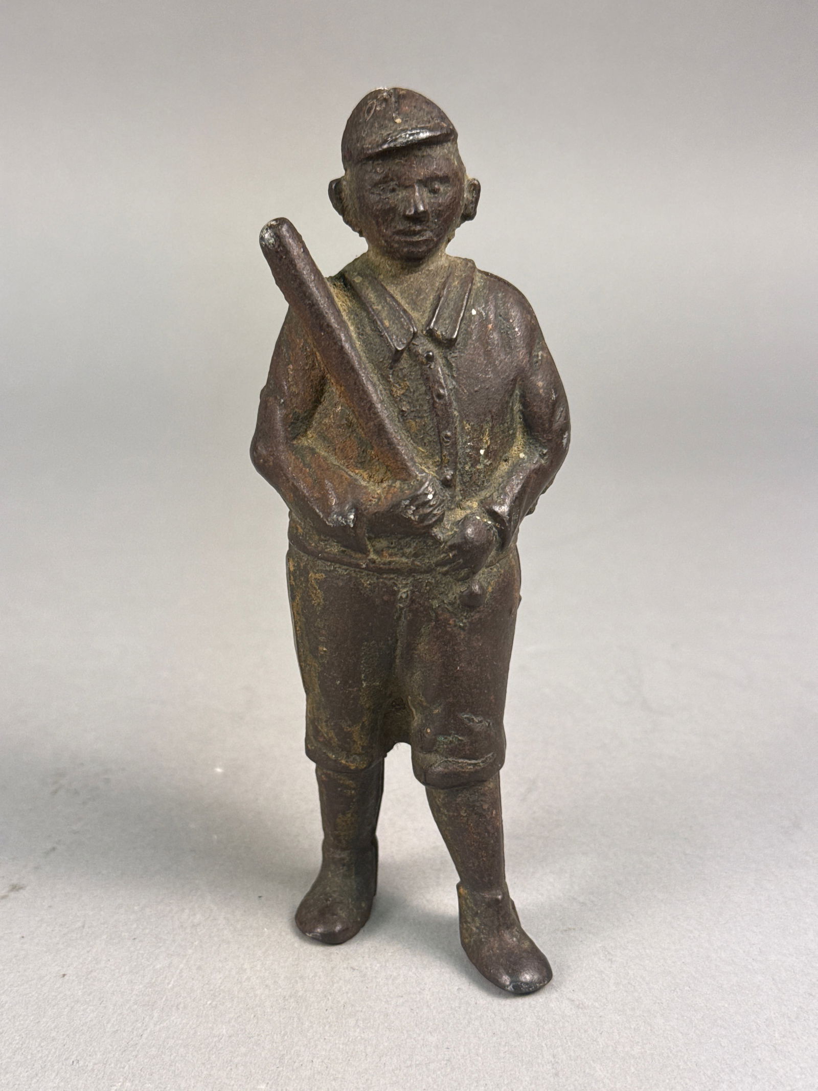 Antique A.C. Williams Cast Iron Baseball Player Still Bank: An antique A.C. Williams cast iron still bank modeled in the form of a baseball player. The figure is depicted in a standing pose holding a bat and wearing a period uniform including a cap, collared j
