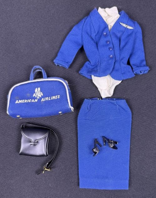 A Collection of Vintage Barbie American Airlines Stewardess Outfit #984 Apparel and Accessories: This collection consists of the Vintage Barbie American Airlines Stewardess Outfit #984. The ensemble includes a blue textured-fabric jacket featuring four decorative buttons and a silver-toned wing p