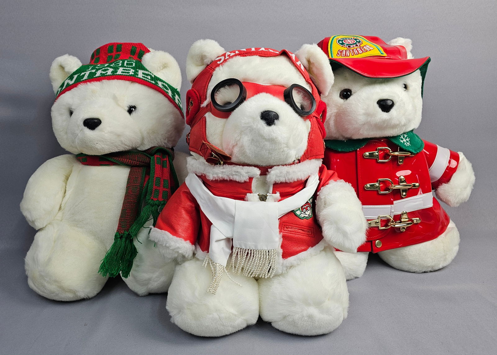 A Collection of Dayton Hudson Santabear Holiday Plush Bear Toys: A collection of Dayton Hudson Santabear holiday plush toys and accompanying plastic drawstring gift bags, produced for Dayton Hudson between 1985 and 1996. The set features a 1985 bear with a green an