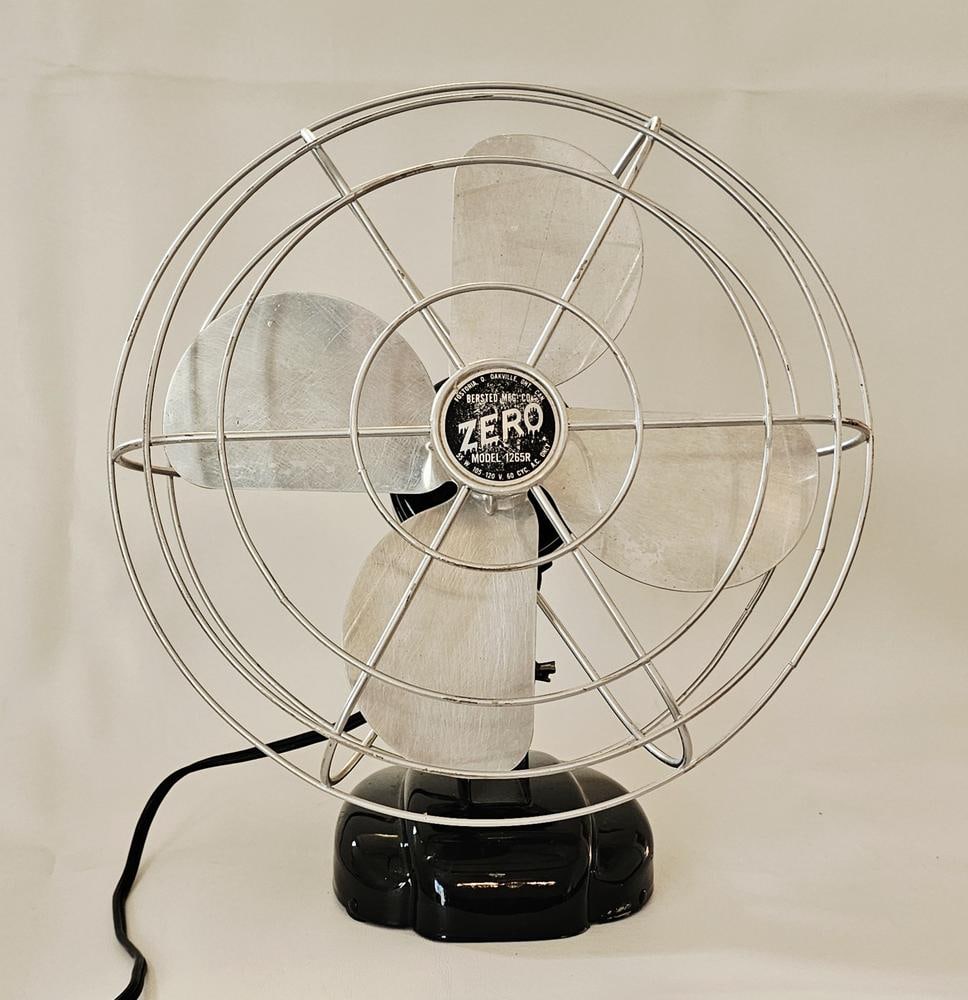 Bersted Mfg. Co. Zero Model 1265R Electric Desk Fan: Bersted Mfg. Co. Zero Model 1265R electric desk fan. This Art Deco-style unit features a black painted metal base and a bullet-shaped motor housing. The fan is constructed with three aluminum blades p