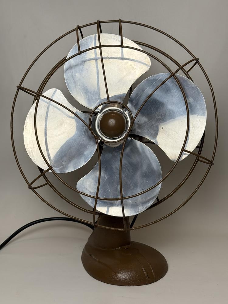 A Mid-Century Industrial Electric Oscillating Table Fan, Model 2128S: This item is located on the second floor. This mid-century industrial electric table fan features a brown-painted cast metal base and a bullet-shaped motor housing. The unit is equipped with four alum